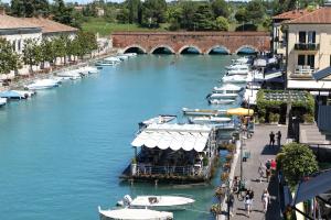 a group of boats are docked in a river at Hotel Bell'arrivo by Dori in Peschiera del Garda