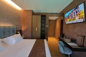 a hotel room with a bed and a flat screen tv at Hotel Bell'arrivo by Dori in Peschiera del Garda