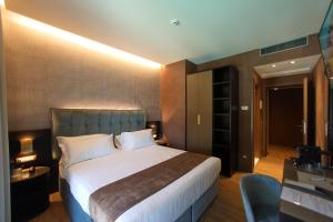 a hotel room with a large bed and a chair at Hotel Bell'arrivo by Dori in Peschiera del Garda