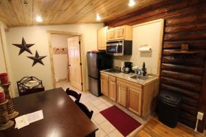 a kitchen with a table and a refrigerator and a counter at The Historic Wapiti Lodge in Wapiti