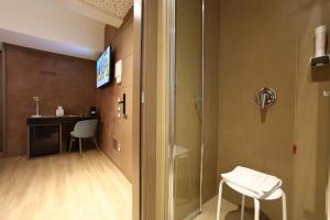 a bathroom with a shower and a table and chairs at Hotel Bell'arrivo by Dori in Peschiera del Garda