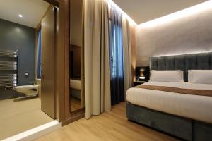 a bedroom with a large bed and a bathroom at Hotel Bell'arrivo by Dori in Peschiera del Garda