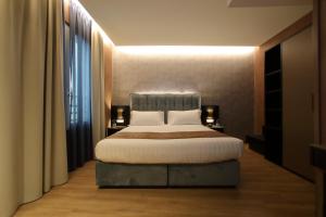a bedroom with a large bed and a large window at Hotel Bell'arrivo by Dori in Peschiera del Garda