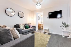 a living room with a couch and a tv at Alma Accommodation - TV in Every Bedroom! in Swansea