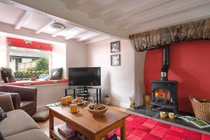 sala de estar con chimenea y sofá en Woodside Cottage with free Spa access en Newby Bridge