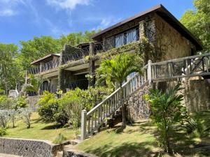 a stone house with a staircase leading up to it at Firefly Estate Bequia in Crescent Beach