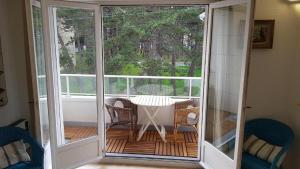un porche cubierto con mesa y sillas en Grand appartement traversant 3 ch hyper-centre+Parking privé. en Le Touquet-Paris-Plage