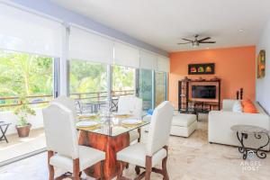 - un salon avec une table, des chaises et un canapé dans l'établissement Casa del Mar by Stella Rentals, à Playa del Carmen