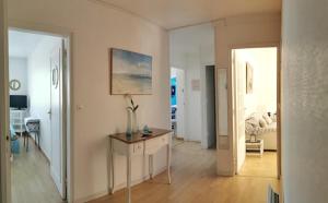 una sala de estar con una mesa con un jarrón. en Grand appartement traversant 3 ch hyper-centre+Parking privé. en Le Touquet-Paris-Plage