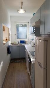 una pequeña cocina con fregadero y nevera. en Grand appartement traversant 3 ch hyper-centre+Parking privé. en Le Touquet-Paris-Plage