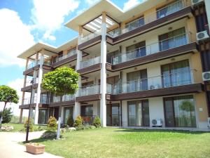 ein Apartmenthaus mit Balkon und Rasen in der Unterkunft July Morning Seaside Resort in Kawarna