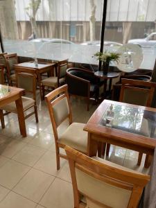 a restaurant with tables and chairs and a window at PIAZZA SUITES in Mendoza