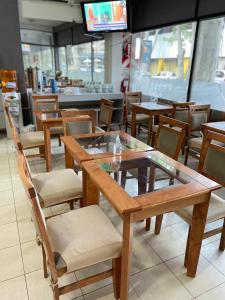PIAZZA SUITES في ميندوزا: غرفة طعام بها طاولات وكراسي وتلفزيون