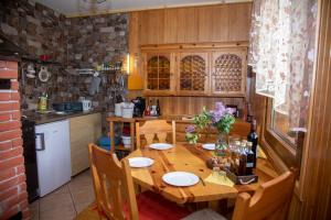 a kitchen with a wooden table with plates and flowers on it at Kuća za odmor Gorski Kotar in Brestova Draga