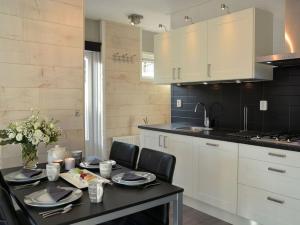 a kitchen with a table with chairs and a sink at Duinnest in Noordwijkerhout