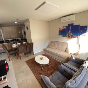 ein Wohnzimmer mit Sofa und Tisch in der Unterkunft Casa Nova Canela Condominio Fechado 40 in Canela