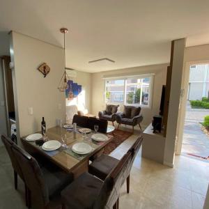 ein Wohnzimmer mit einem Holztisch und Stühlen in der Unterkunft Casa Nova Canela Condominio Fechado 40 in Canela