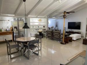 a living room with a table and chairs and a tv at Firefly Estate Bequia in Crescent Beach