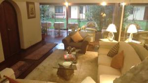 una sala de estar con sofás blancos y una mesa. en Villas Del Sol Bed & Breakfast, en Lima