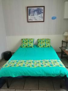 Chez Christian في Désertines: سرير في غرفة مع لحاف أخضر