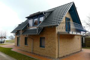 een klein bakstenen gebouw met een balkon bij Ferienhaus direkt an See & Strand in Göhren-Lebbin