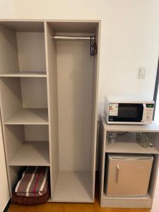 a white closet with a microwave on top of it at Piazza Suites 2 in Mendoza +9 photos