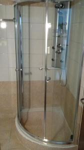 W łazience znajduje się prysznic ze szklanymi drzwiami. w obiekcie Diethnes w mieście Larisa