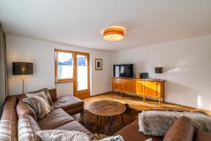 a living room with a couch and a tv at Ferienwohnung Marlies in Bartholomäberg