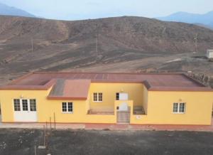 una casa amarilla con una montaña en el fondo en Casa rural,Naturaleza,Vacaciones en Teguitar