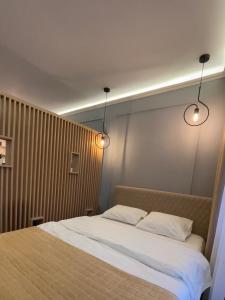 - une chambre avec un lit avec deux oreillers et deux lumières dans l'établissement BW Luxury Apartment Bijeljina, à Bijeljina