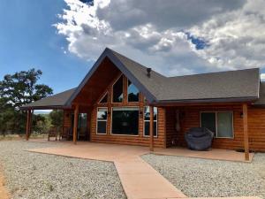 a log cabin with a patio in front of it at Skyfall Cabin. Stunning views, Hot Tub, minutes from Zion in Orderville +13 photos