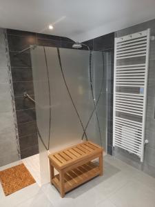 een douche met een houten bank in de badkamer bij Gite de la Creuse (Vosges) in Fays