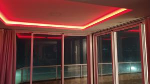 een kamer met een rood plafond en glazen ramen bij Apartamento de Cobertura frente para o mar Itapema in Itapema