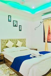 a bedroom with a large bed with a blue ceiling at Zcube Andaman in Port Blair