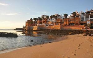 a beach with houses and footprints in the sand at BOUZNIKA Bâtiment F in Bouznika