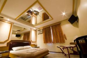 a small bedroom with a bed and a mirror at Hotel Paraguai (Adult Only) in Rio de Janeiro