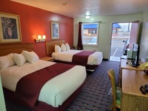 una camera d'albergo con due letti e una televisione di Relax Inn a Marshall