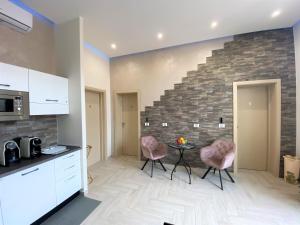a kitchen with two pink chairs and a table at B&B De Nava Suite in Reggio di Calabria