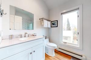 a bathroom with a sink and a toilet and a window at Old Town Cottage in Steamboat Springs +23 photos
