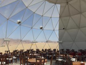 The Rock Camp Petra في وادي موسى: خيمة كبيرة فيها طاولات وكراسي في ميدان