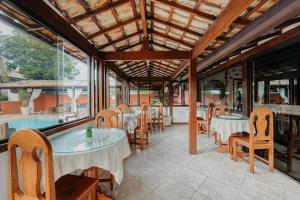 a restaurant with tables and chairs and a pool at Búzios Centro Hotel in Búzios +31 photos