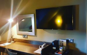 a desk with a tv on the wall of a room at Garth Hotel in Grantown on Spey
