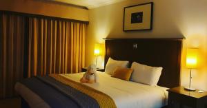 a teddy bear sitting on a bed in a hotel room at Garth Hotel in Grantown on Spey +22 photos