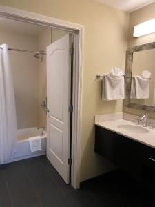 een badkamer met een douche, een wastafel en een bad bij Staybridge Suites Syracuse Liverpool, an IHG Hotel in Liverpool