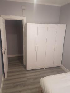 biała sypialnia z białymi szafkami i łóżkiem w obiekcie Bilbao Cozy Apartment with free Wifi w mieście Bilbao