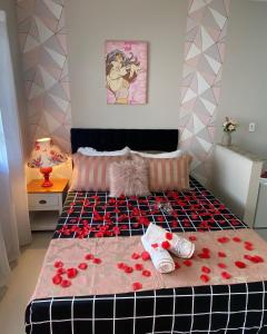 a bedroom with a bed with red roses on it at Vila Noel Centro in Penedo