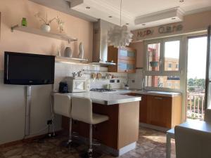 a kitchen with a kitchen island with a tv in it at Ciampino Airport Apartment in Ciampino