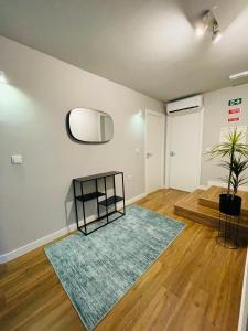 an empty living room with a rug and a mirror at Duque de Loulé in Porto