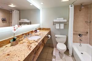
a bathroom with a toilet, sink, and bathtub at Carlyle Inn in Los Angeles
