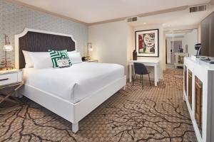 a bedroom with a large white bed and a fireplace at Carlyle Inn in Los Angeles